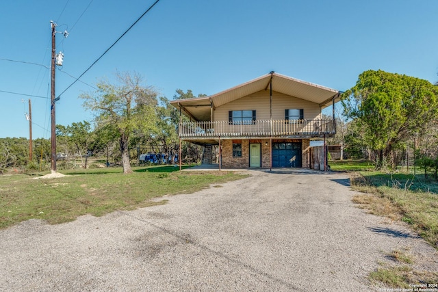 view of property featuring a garage, a deck, and a front lawn