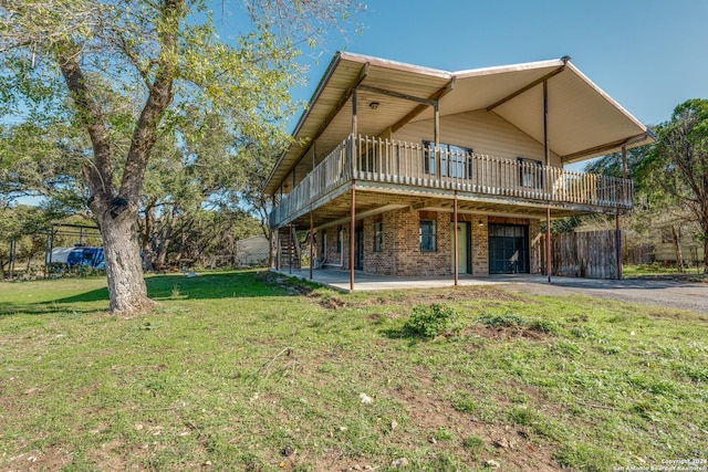 back of house featuring a wooden deck, a patio area, and a yard