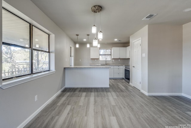 kitchen featuring white cabinetry, light hardwood / wood-style flooring, kitchen peninsula, decorative light fixtures, and stainless steel range with electric stovetop