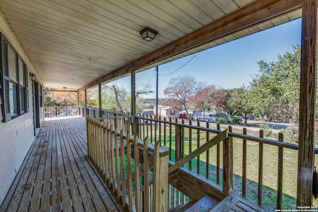 deck with covered porch and a yard