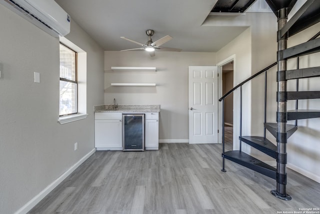 kitchen with white cabinetry, sink, beverage cooler, a wall mounted air conditioner, and light hardwood / wood-style floors