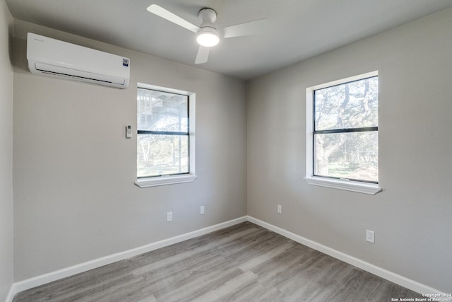 unfurnished room featuring a wall mounted AC, ceiling fan, and light hardwood / wood-style floors