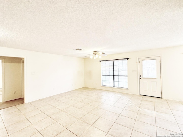 empty room with light tile patterned floors and a textured ceiling