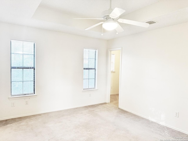 empty room featuring light carpet, plenty of natural light, and ceiling fan