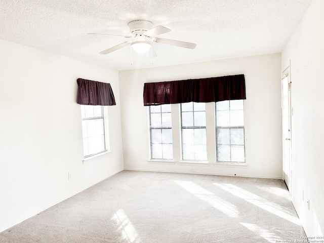 empty room with light carpet, a textured ceiling, and ceiling fan