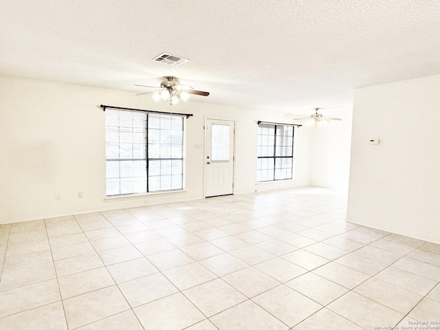 unfurnished room with light tile patterned floors and a textured ceiling