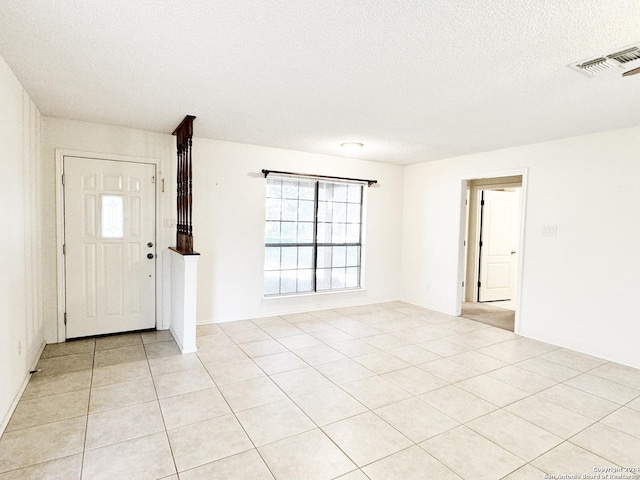 tiled foyer entrance with a textured ceiling