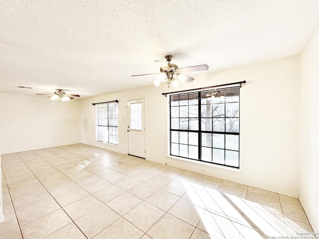 tiled spare room with ceiling fan and a textured ceiling