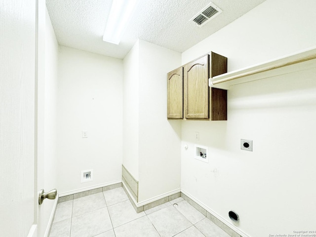 laundry room featuring cabinets, washer hookup, hookup for an electric dryer, a textured ceiling, and light tile patterned floors