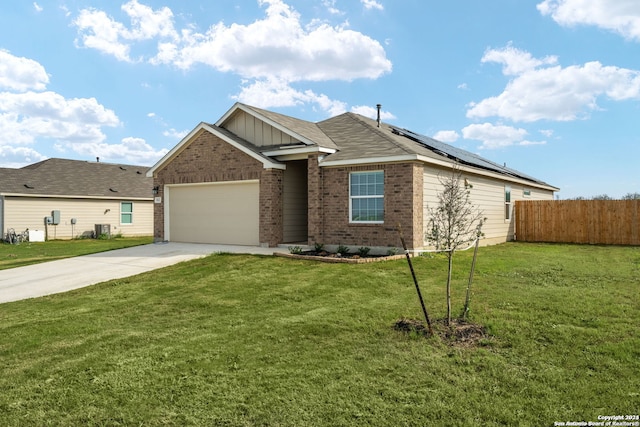 view of front of house featuring solar panels, a garage, and a front lawn