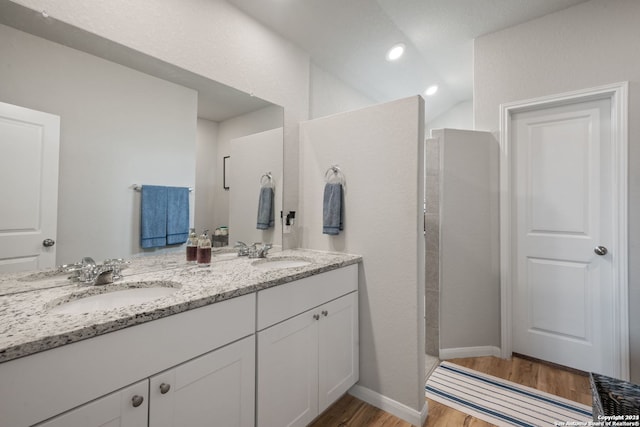 bathroom with hardwood / wood-style floors, vanity, and walk in shower