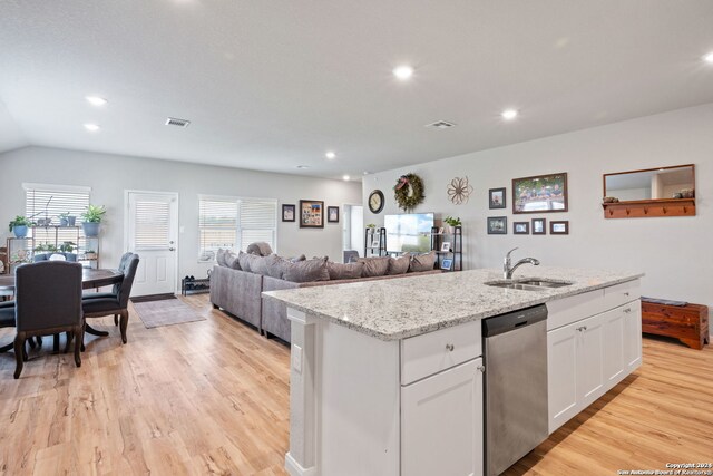 kitchen with dishwasher, white cabinets, a center island with sink, sink, and light hardwood / wood-style flooring