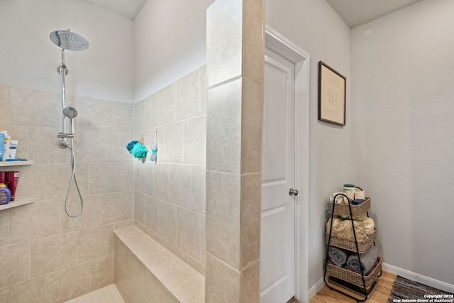 bathroom featuring hardwood / wood-style flooring and a tile shower