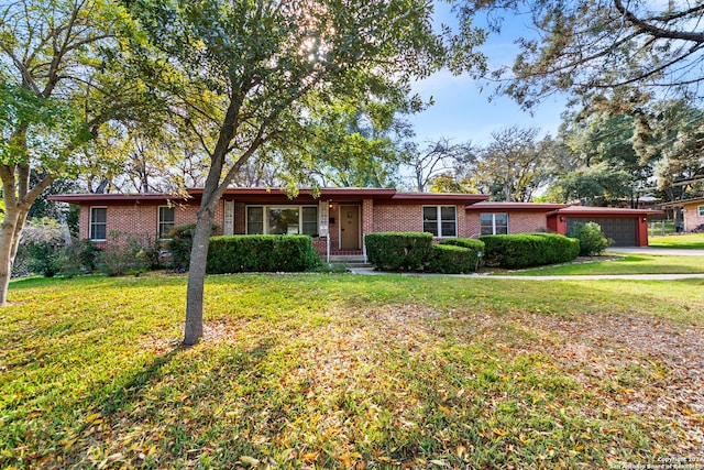 ranch-style house featuring a garage and a front lawn