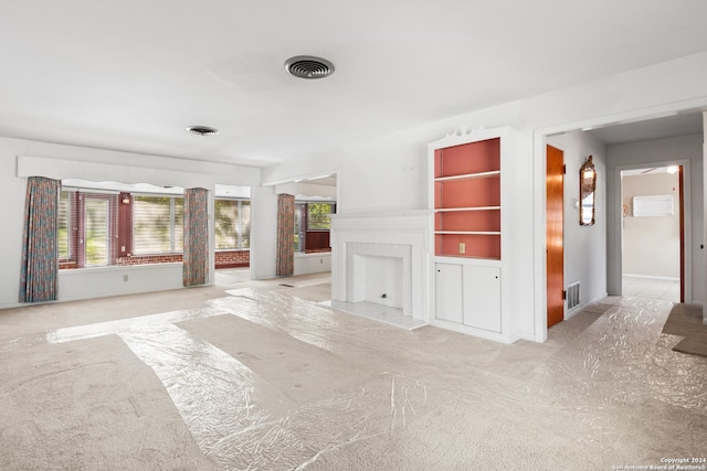 unfurnished living room with a healthy amount of sunlight and light colored carpet