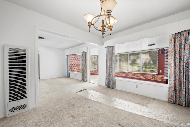 carpeted spare room with a chandelier