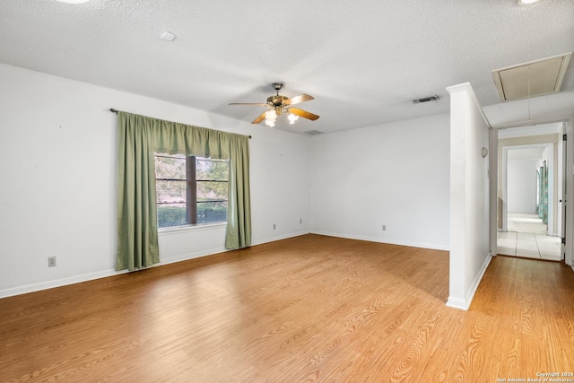 spare room featuring ceiling fan, light hardwood / wood-style flooring, and a textured ceiling