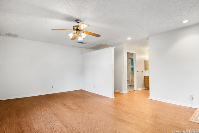 spare room featuring light wood-type flooring, a textured ceiling, and ceiling fan