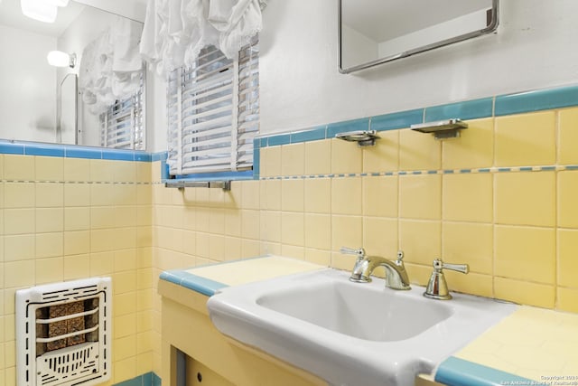 bathroom with vanity, heating unit, and tile walls