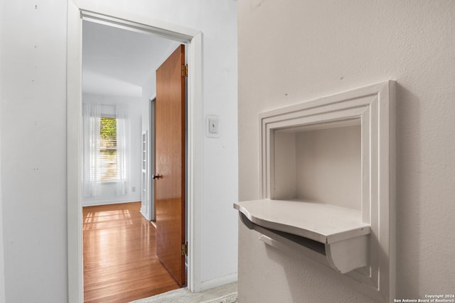 corridor with hardwood / wood-style flooring