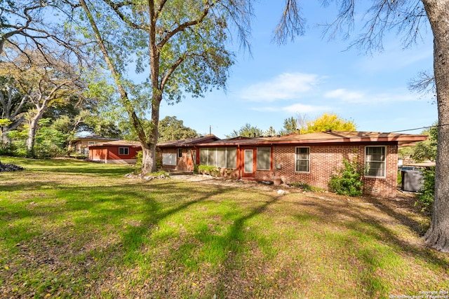 rear view of property with a lawn