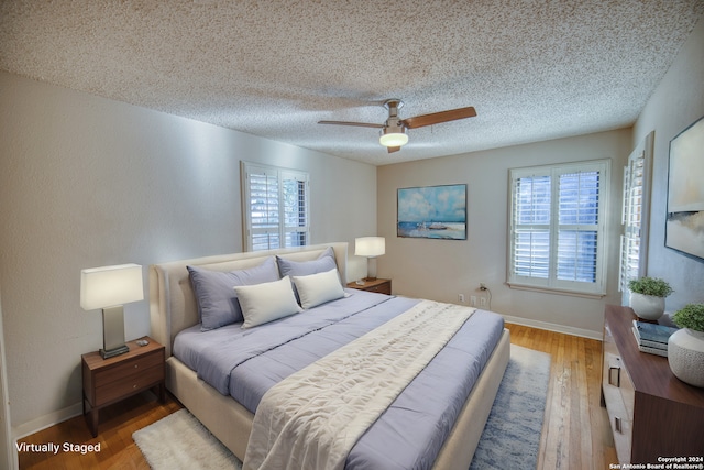 bedroom featuring hardwood / wood-style floors, a textured ceiling, and ceiling fan