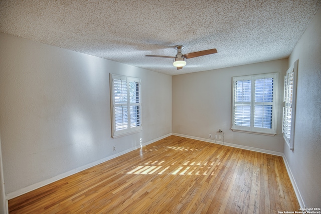 empty room with wood-type flooring, a textured ceiling, and ceiling fan