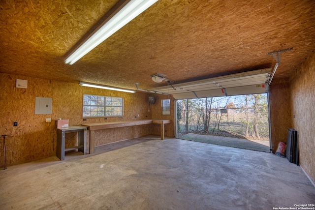 garage with a workshop area and electric panel