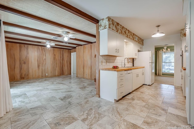 kitchen with white appliances, ceiling fan with notable chandelier, sink, beamed ceiling, and white cabinets