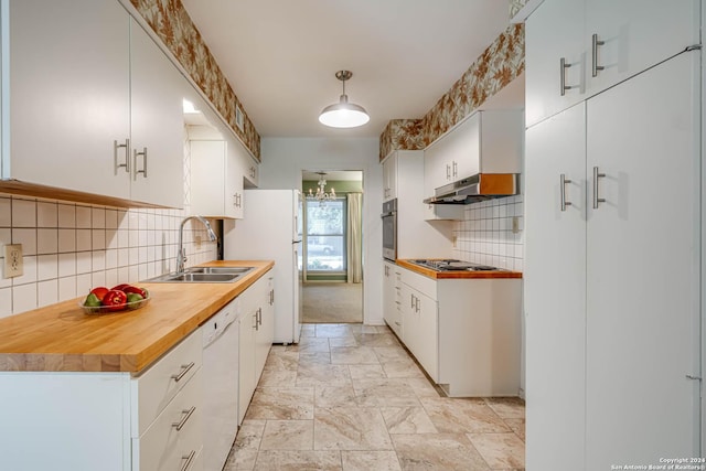 kitchen with white cabinets, sink, appliances with stainless steel finishes, tasteful backsplash, and decorative light fixtures