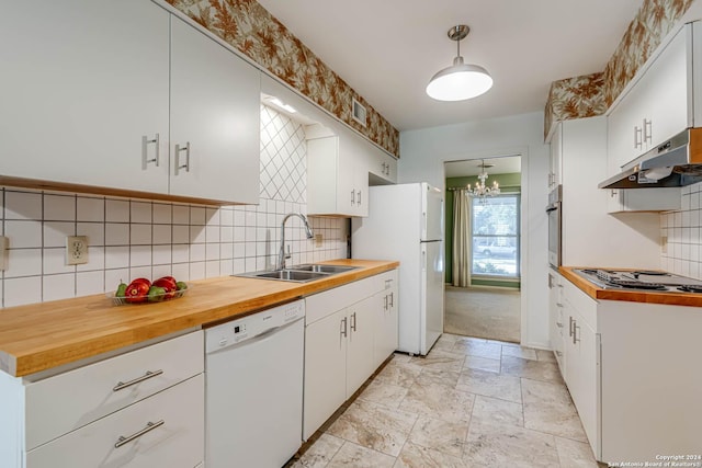 kitchen with decorative backsplash, stainless steel appliances, sink, pendant lighting, and white cabinetry