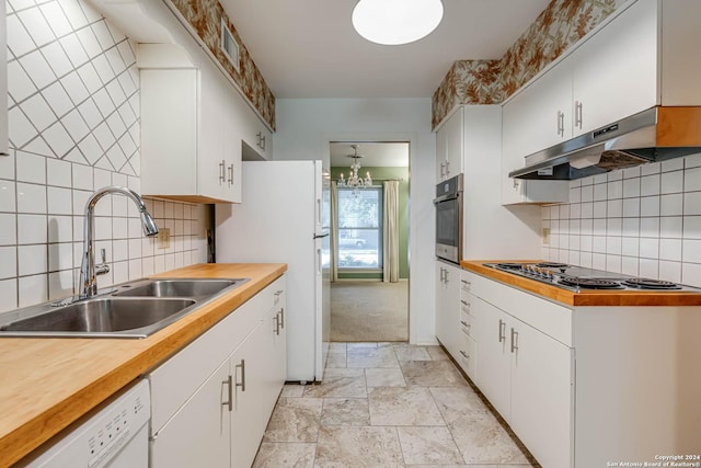 kitchen with sink, stainless steel appliances, an inviting chandelier, tasteful backsplash, and white cabinets