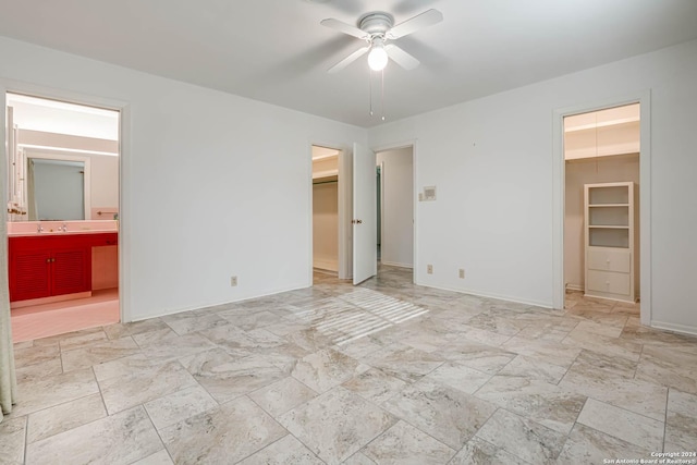 unfurnished bedroom featuring sink, ensuite bath, ceiling fan, a spacious closet, and a closet