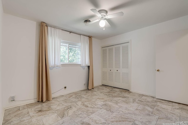 unfurnished bedroom with ceiling fan and a closet