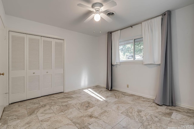 unfurnished bedroom featuring ceiling fan and a closet