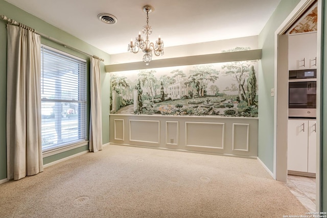 spare room with light carpet, a wealth of natural light, and a notable chandelier