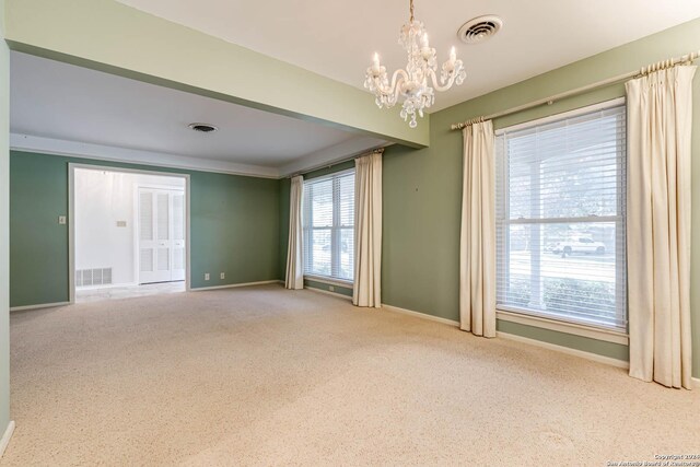 carpeted spare room with a chandelier