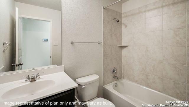 full bathroom featuring tiled shower / bath combo, toilet, and vanity