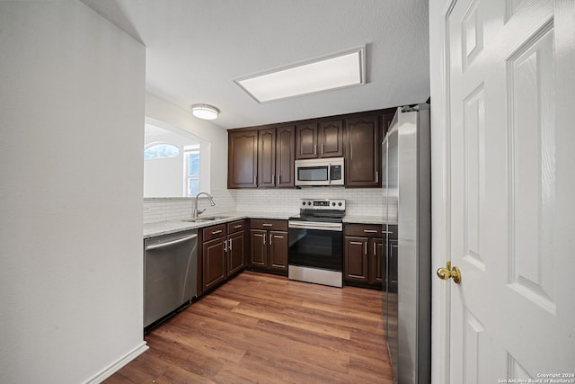 kitchen with dark brown cabinets, stainless steel appliances, dark wood-type flooring, and sink