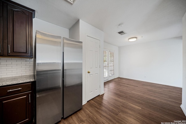 kitchen with backsplash, stainless steel fridge, dark brown cabinets, and dark hardwood / wood-style floors