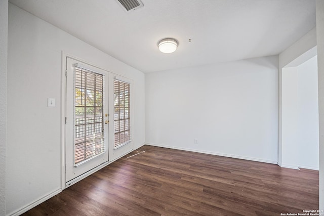 empty room featuring french doors and dark hardwood / wood-style floors