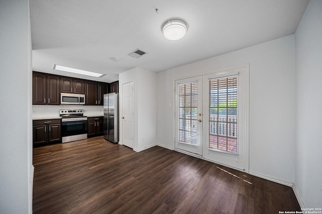 kitchen featuring french doors, tasteful backsplash, dark brown cabinets, dark hardwood / wood-style flooring, and stainless steel appliances