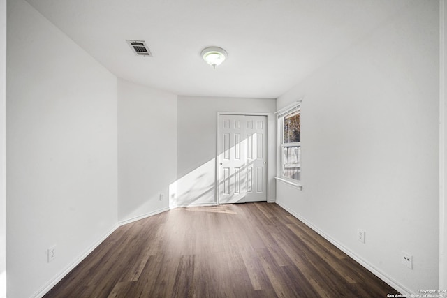 unfurnished room with dark wood-type flooring