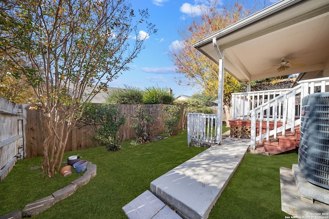 view of yard with ceiling fan, cooling unit, and a wooden deck