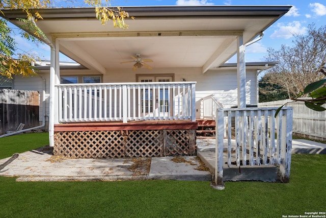 wooden deck featuring a lawn, ceiling fan, and a patio