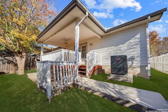 back of property with central AC, ceiling fan, a wooden deck, and a lawn