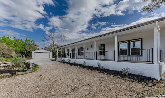 single story home featuring an outbuilding, covered porch, and a garage