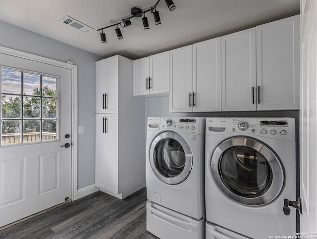 laundry room featuring rail lighting, cabinets, dark hardwood / wood-style floors, independent washer and dryer, and a textured ceiling