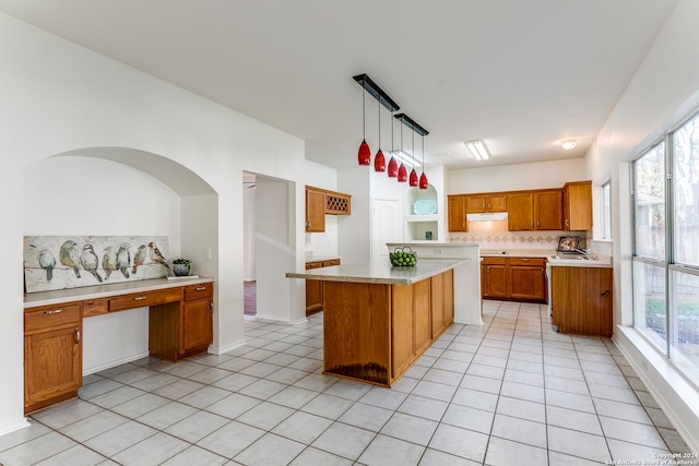 kitchen featuring pendant lighting, backsplash, a kitchen island, and plenty of natural light