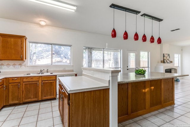 kitchen with decorative light fixtures, light tile patterned floors, sink, and a wealth of natural light